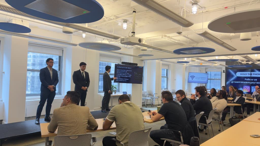 Founders pitching on stage to a seated audience at BoilerLaunch